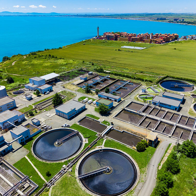 Aerial view of a wastewater and stormwater treatment plant near the coast monitored with SWPPP software.